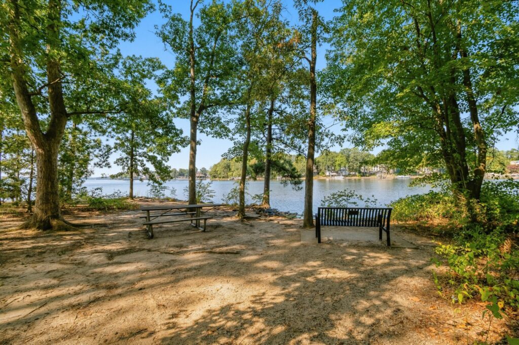 Park benches by the shore under the shade of trees at Jetton Park