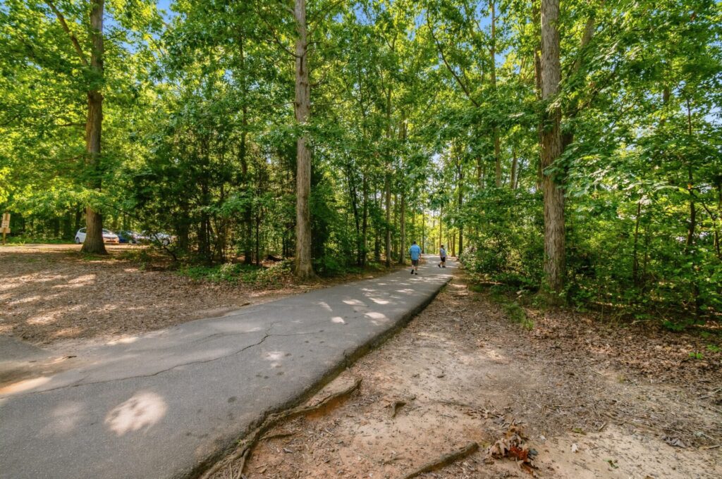 People walking along a paved pathway in Jetton Park in Cornelius, NC