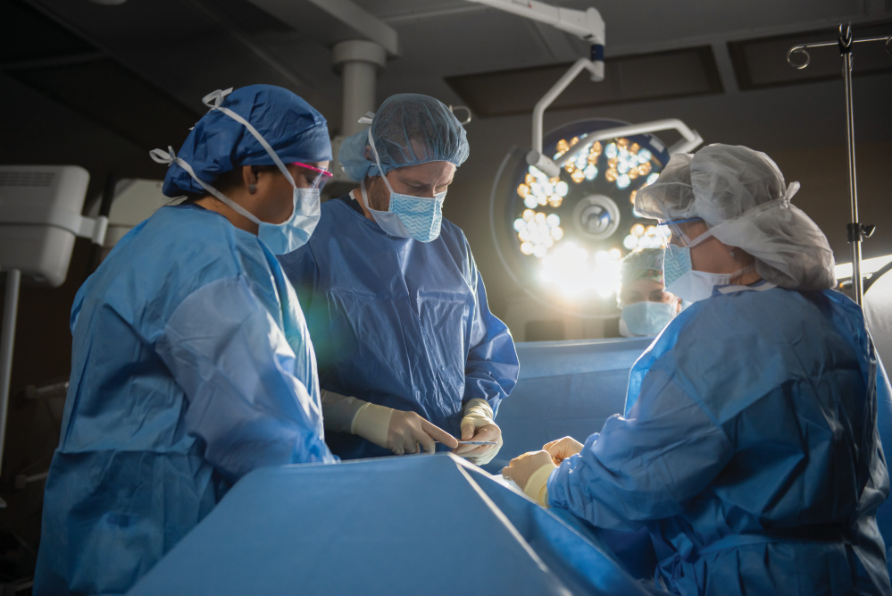 Doctors and nurses in PPE during surgery in operating room