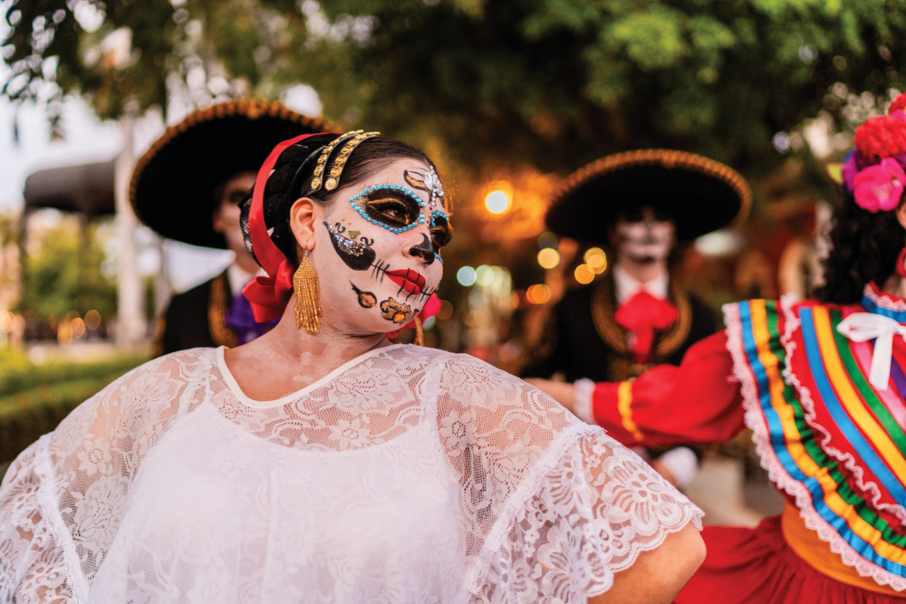 Young woman dancing and celebrating the Day of the Dead outdoors