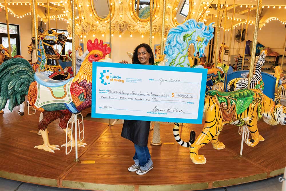 Operations Manager Janvi Shivdasani holds a check from money collected by The Circle of Giving from riders for local charities at Carousel of Dreams by Ken Means at The Factory at Franklin, in Franklin, Tennessee.