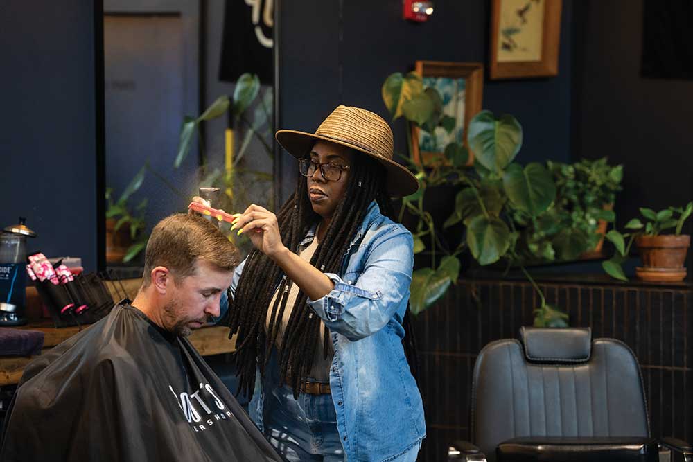 Barbers cutting clients’ hair inside the bright, industrial-style Scout’s Barber Shop at Canteen on Carothers in Franklin, TN