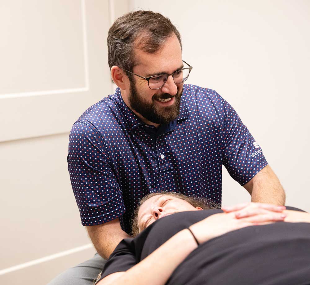 Dr. Bradley Krock performing a hands-on chiropractic adjustment on a patient lying on a treatment table at his Franklin, Tennessee, clinic