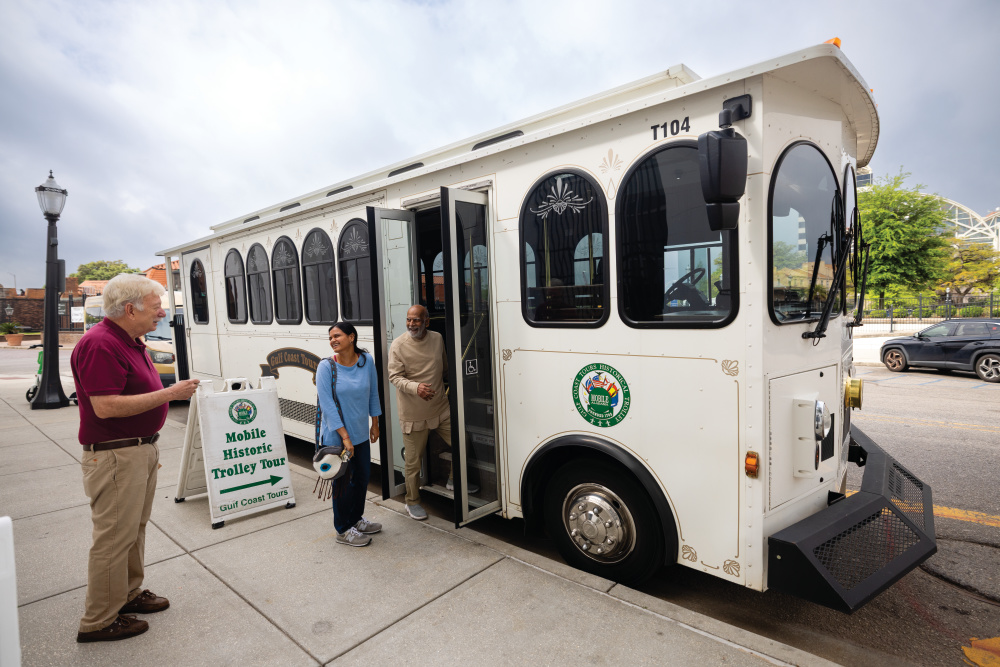 Arthur Clevenger, left, gives people a tour of downtown on a trolley in Mobile.