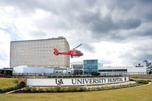 USA Health University Hospital exterior with USA Health SouthFlight helicopter