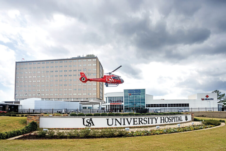 USA Health University Hospital exterior with USA Health SouthFlight helicopter