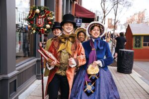 Carolers in Victorian costume singing on Main Street during Dickens of a Christmas in downtown Franklin, TN