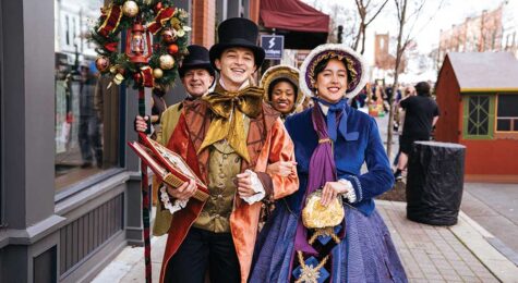 Carolers in Victorian costume singing on Main Street during Dickens of a Christmas in downtown Franklin, TN