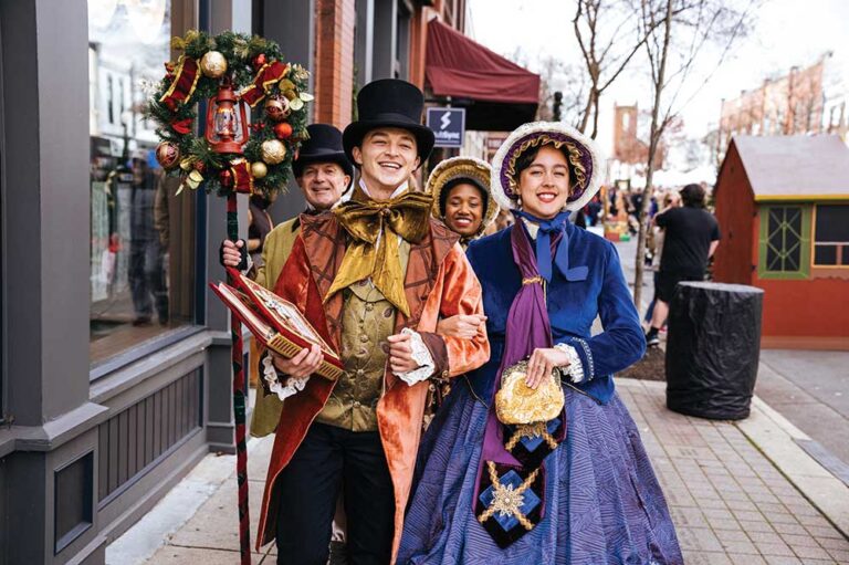Carolers in Victorian costume singing on Main Street during Dickens of a Christmas in downtown Franklin, TN